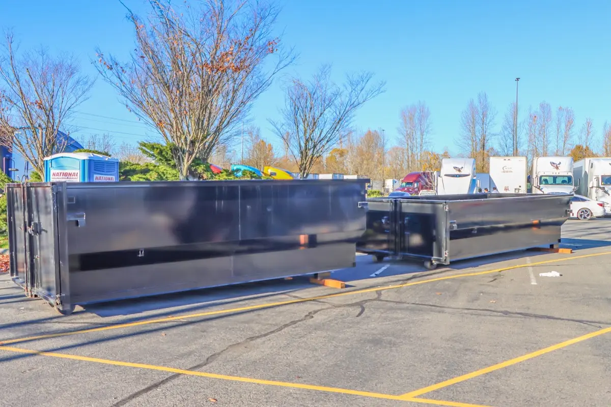 Professional dumpster rental service with roll-off container on residential driveway in Flowood